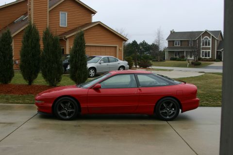 1993 Ford Probe - Side view of a red 1993 Ford Probe parked in a suburban driveway.