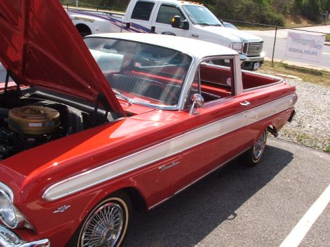 1966 Ford Ranchero - A classic red and white Ford Ranchero is displayed with its hood up, parked beside a modern pickup truck.