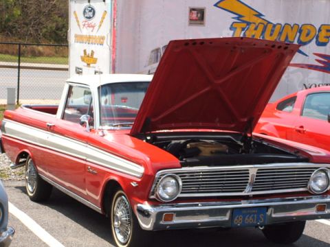 1966 Ford Ranchero - A red and white 1966 Ford Ranchero is parked with its hood up, revealing the engine compartment.