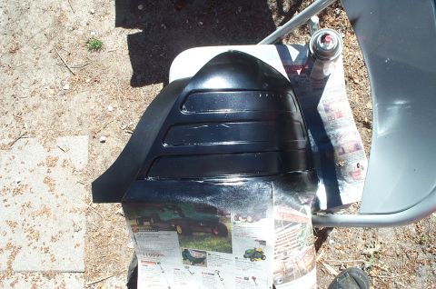 1999 Ford Crown Victoria - A car tail light housing is being painted black outdoors.