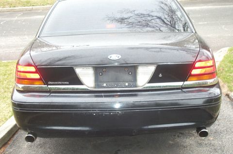 1999 Ford Crown Victoria - The rear of a black Ford Crown Victoria is shown, its distinctive taillights and chrome accents.