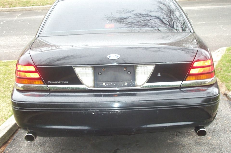 Rear view of a black 1999 Ford Crown Victoria with chrome trim and dual exhaust pipes