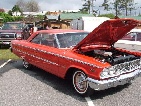 1966 Ford Ranchero - A bright red 1963 Ford Galaxie 500 coupe is displayed with its hood open, parked outdoors.