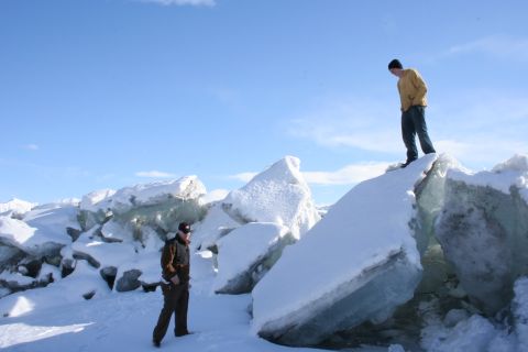 1995 Jeep Cherokee - Two individuals explore a landscape of broken ice and snow under a clear blue sky.