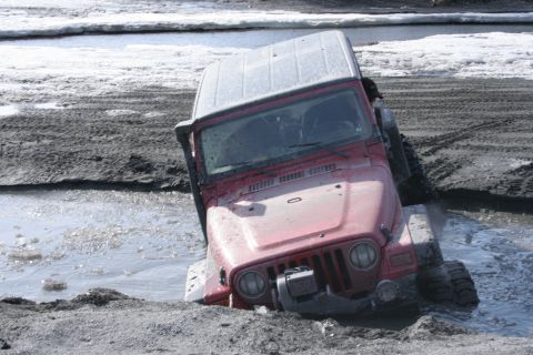 1995 Jeep Cherokee - This Jeep Wrangler appears to be stuck in a muddy, watery area, with its front tires deep in the mire.
