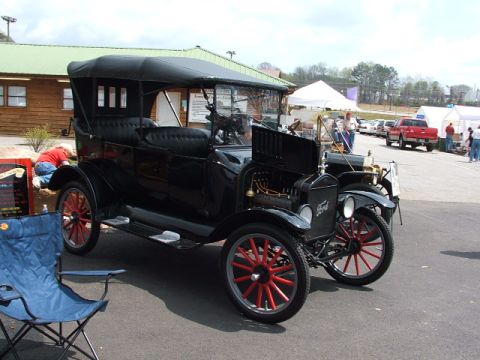 1966 Ford Ranchero - A black Ford Model T touring car is parked at an outdoor event with other vehicles visible.