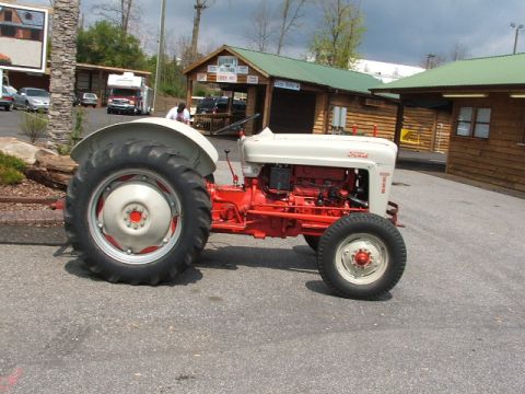 1966 Ford Ranchero - This Ford tractor, likely from the mid-1950s, is parked outdoors near wooden buildings.