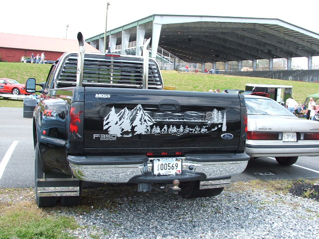 Black Ford F-350 Super Duty pickup truck with a mountain and ATV rider decal on the tailgate