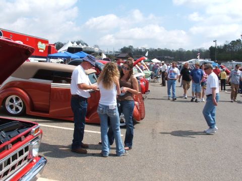 1966 Ford Ranchero - People gather around a custom orange convertible hot rod at an outdoor car show.