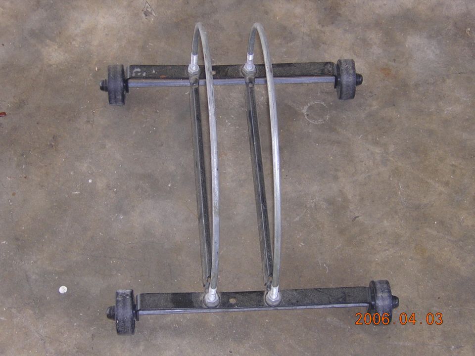 Bicycle wheel storage stand with two hoops and black cross rails lying on concrete floor