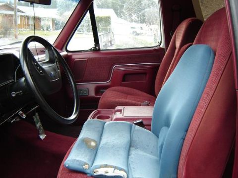 1990 Ford Bronco - Interior view of a 1990 Ford Bronco, highlighting the maroon upholstery and dashboard details.