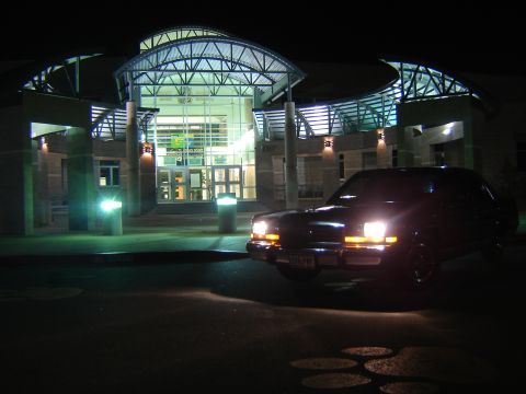 1988 Ford Crown Victoria LTD - A 1988 Ford Crown Victoria LTD is seen parked in front of a contemporary building at night.