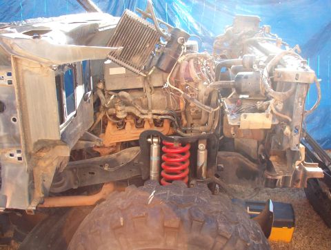 1994 Ford Bronco - The front section of a vehicle is disassembled, revealing the engine, radiator, and suspension components.