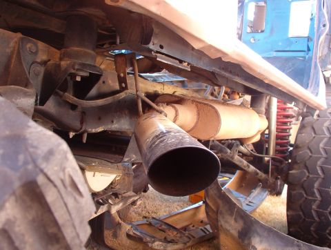 1994 Ford Bronco - Close-up view of the exhaust system and suspension components on a vehicle, with visible "SUPERMOTORS.NET" text.