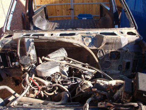 1994 Ford Bronco - The engine compartment of a vehicle is exposed after its body has been removed.