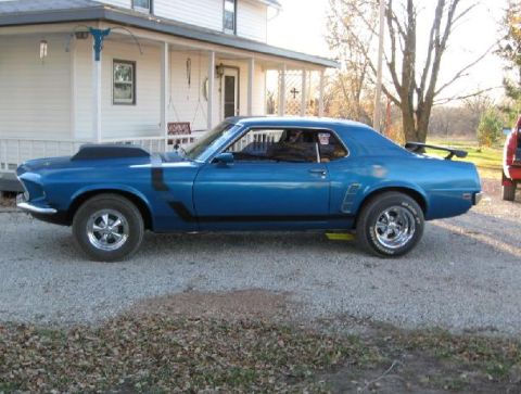 1969 Ford Mustang - Side view of a blue 1970 Ford Mustang Boss 302 with a hood scoop and black racing stripes.
