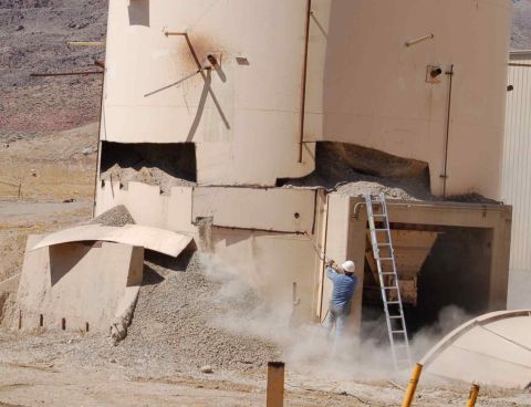 1979 Ford Bronco - Worker on ladder at damaged industrial silo, dust rising. Supermotors.net logo visible.