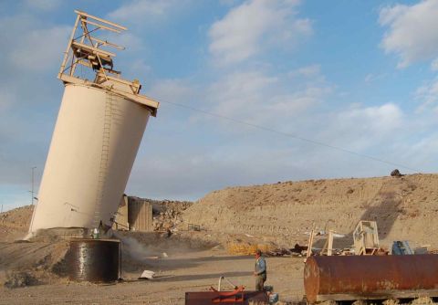 1979 Ford Bronco - A large silo appears to have collapsed or is in the process of falling over at a construction site.