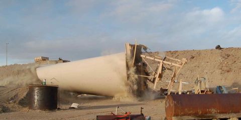 1979 Ford Bronco - A large cylindrical object is collapsing, creating a cloud of dust and debris, with wooden supports visible.