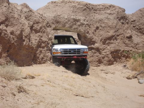 1996 Ford Bronco - 1996 Ford Bronco navigates a narrow passage in a desert canyon.