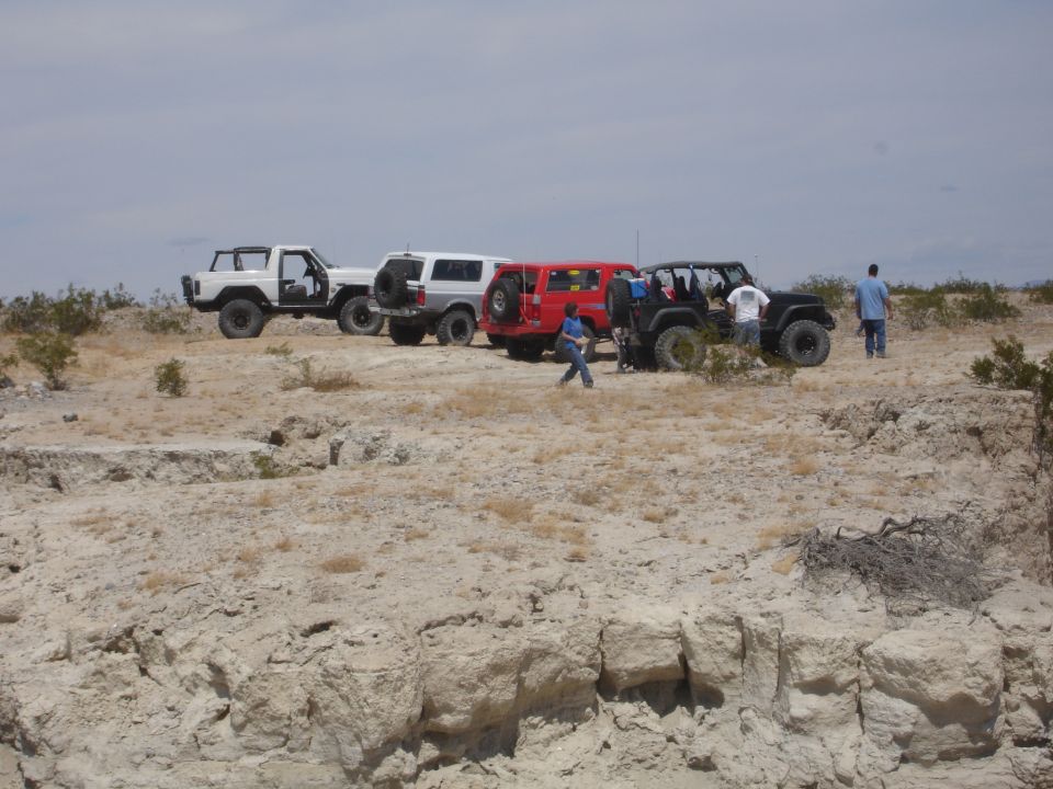 1996 Ford Bronco and three other off-road vehicles parked on a desert landscape