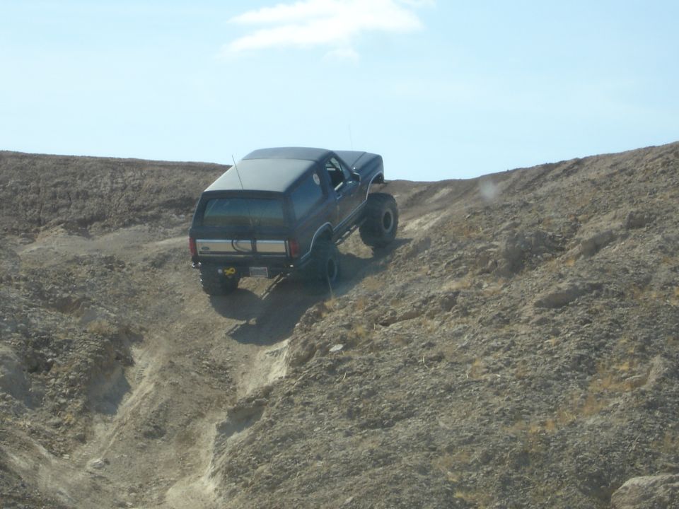 Black 1996 Ford Bronco climbing a steep, rocky hill off-road