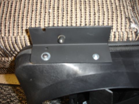 1996 Ford Bronco - A black metal bracket is bolted to a piece of black plastic trim.