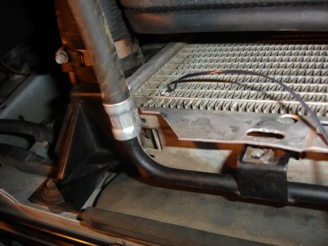 1996 Ford Bronco - Close-up view of a vehicle's radiator and hose assembly, showing a metal bracket and clamp.