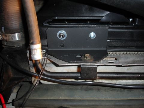 1996 Ford Bronco - A bracket is attached to the radiator fan shroud, with a hose and wiring nearby.