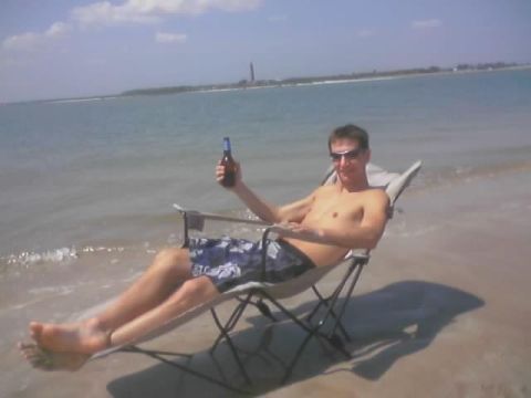 1989 Ford Bronco - A man relaxes on the beach with a beer, enjoying the ocean view.