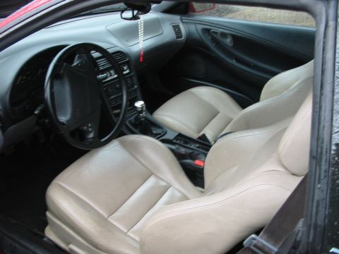1996 Ford Probe - Interior view of a car tan leather seats and a black dashboard with a manual gear shifter.