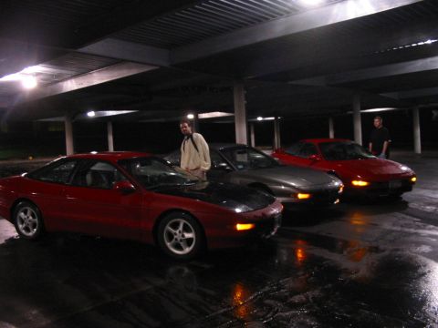 1996 Ford Probe - Three Ford Probes are parked in a covered lot, with two people standing near them.