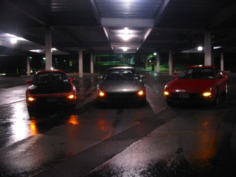 1996 Ford Probe - Three Ford Probes are parked in a covered lot at night, reflecting on the wet ground.