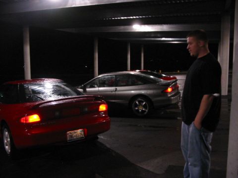 1996 Ford Probe - Two Ford Probes, a red one and a silver one, are parked under a covered area at night.