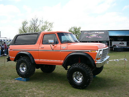 1978 Ford Bronco - This orange 1978 Ford Bronco features a lifted suspension and oversized tires, giving it a stance.