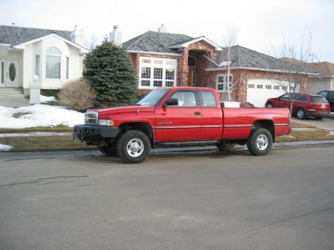 1996 Dodge 2500 - This red 1996 Dodge 2500 pickup truck is parked on a residential street.