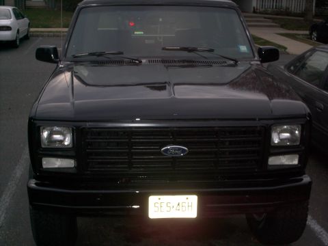 1982 Ford Bronco - Front view of a black Ford Bronco, showing its grille and license plate.