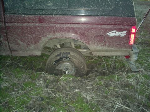 1994 Ford Bronco - This truck is stuck in the mud, with its rear wheel completely submerged in the mire.