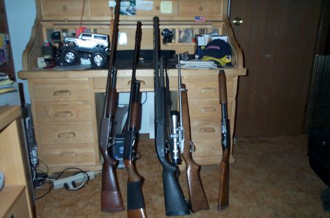 1984 Ford Bronco - A collection of rifles displayed on a desk with a toy Bronco model.