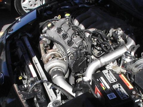 1994 Ford Probe - The engine bay features a turbocharger and custom piping, suggesting performance modifications.