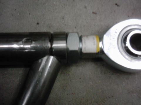 1978 Ford Bronco - A close-up view of a metal suspension part, possibly a radius arm, with visible hardware and a bearing assembly.