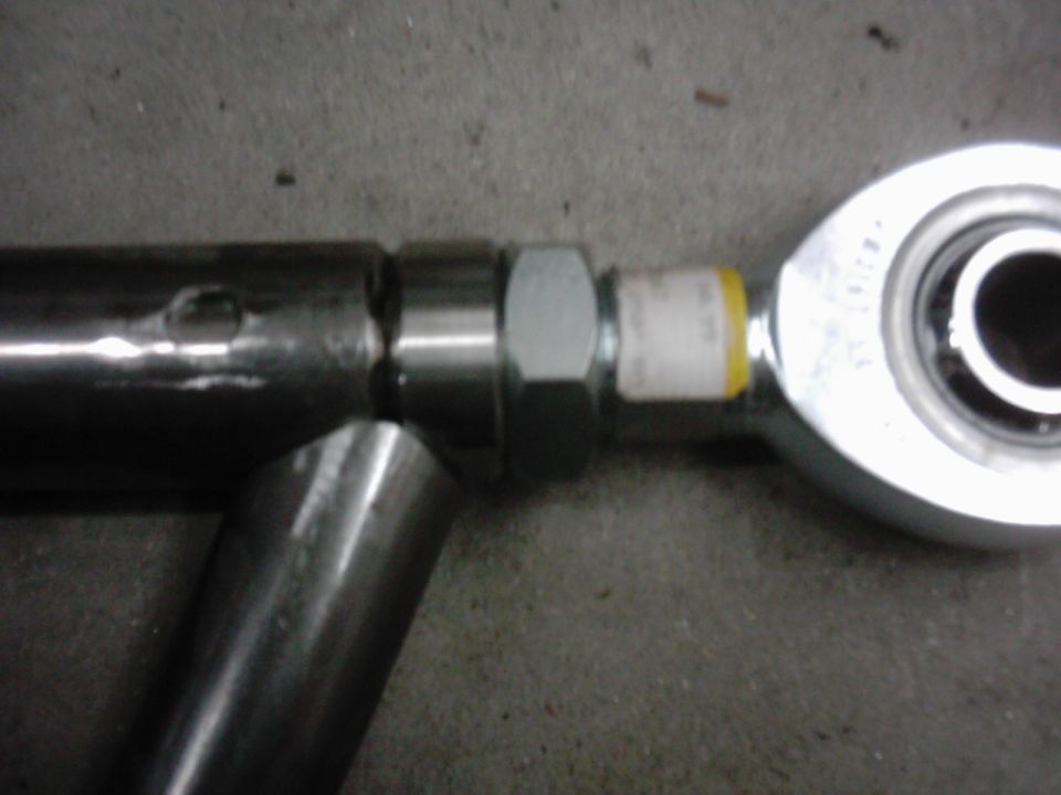 Close-up of a metal suspension component with a hex nut and a bearing end