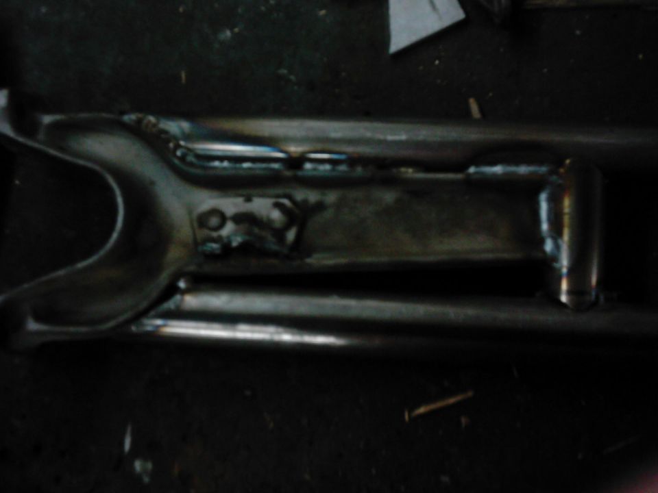 Metal suspension component with visible welds and mounting points
