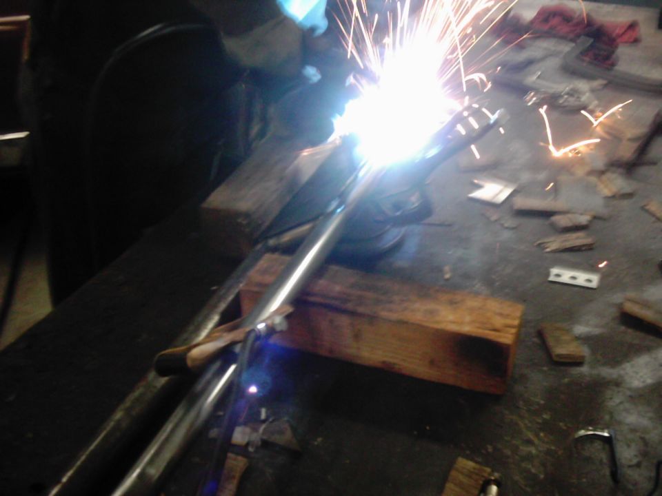 Welding a metal suspension part in a workshop