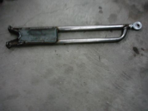 1978 Ford Bronco - A single suspension radius arm is shown lying on a concrete surface.