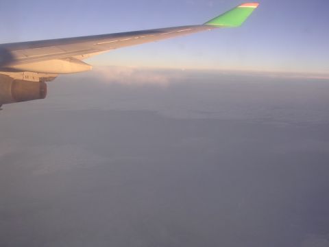 1999 Toyota Tacoma - View from an airplane window shows the wing and engine against a sky filled with clouds during sunset.