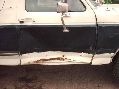 1988 Ford Bronco - This 1988 Ford Bronco shows extensive rust and damage on its side door panel.
