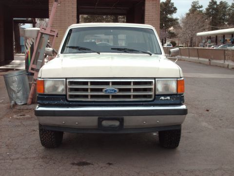 1988 Ford Bronco - This Ford F-Series truck features a prominent grille and '4x4' badging, indicating its four-wheel-drive capability.