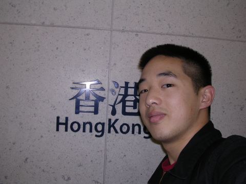 1999 Toyota Tacoma - A man poses for a photo in front of a sign that reads 'Hong Kong'.