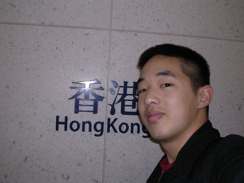 Man in front of Hong Kong sign